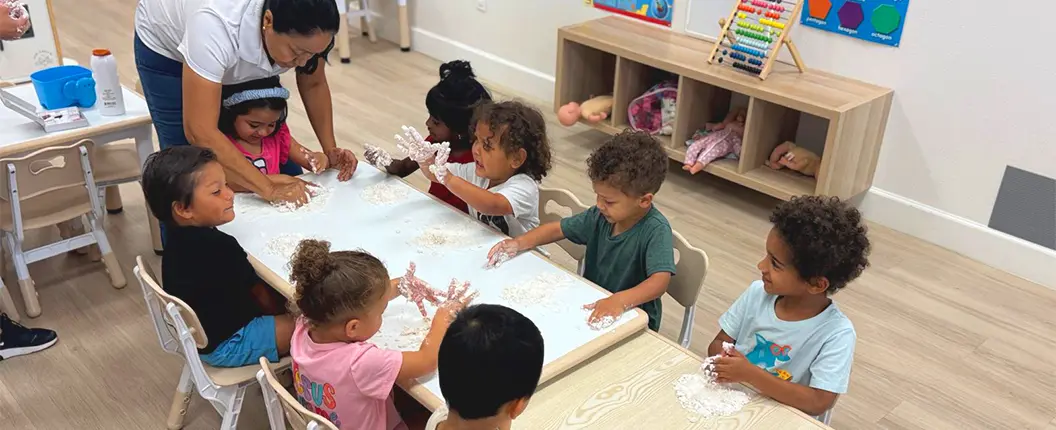 Preschool teacher interacting with children during an educational activity at a daycare center