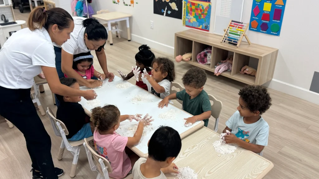preschool teachers making activities with little kids in a childcare center